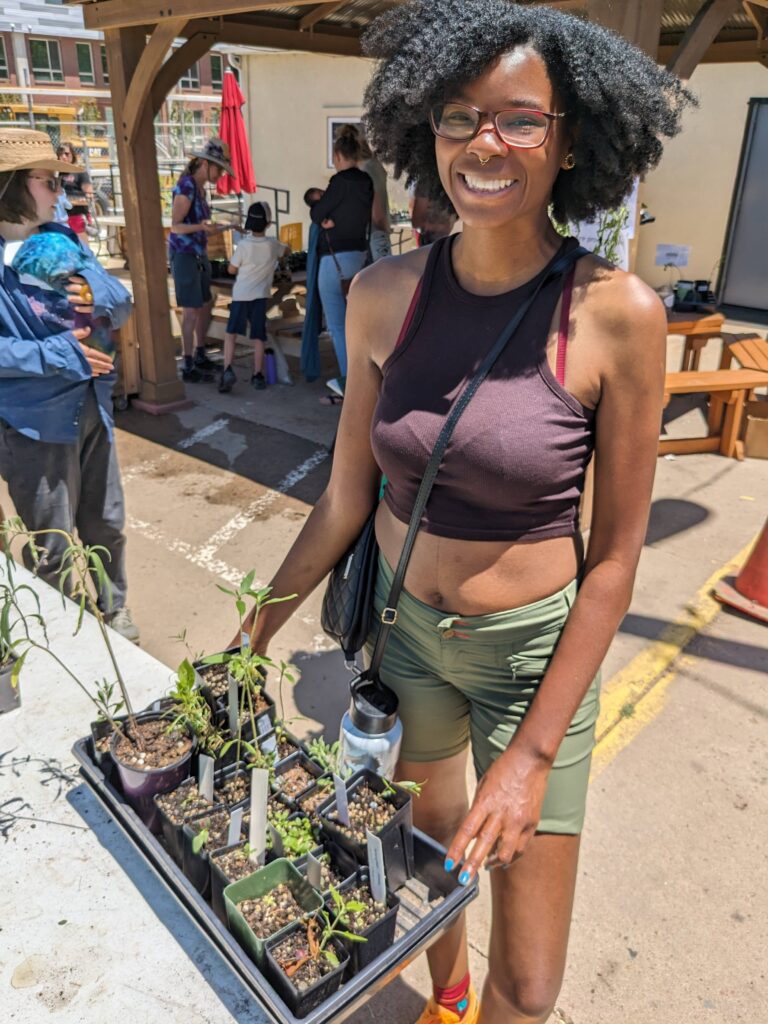 Young woman is beaming after picking out native plants at the swap.