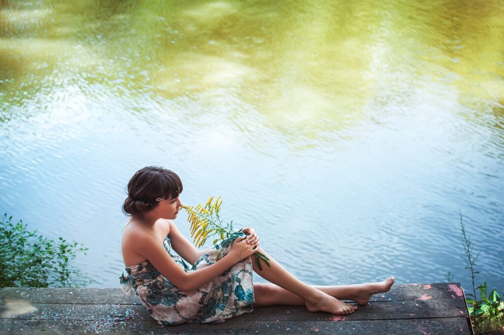 Girl smelling a goldenrod.